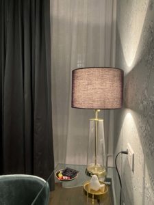 Visuel de l'intérieur de la chambre avec une table en verre, un luminaire et une chaise