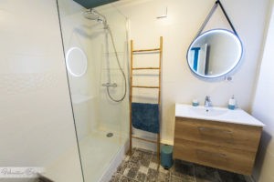 Visuel d'une salle de bain plus précsiement de la douche à gauche et du lavabo à droite